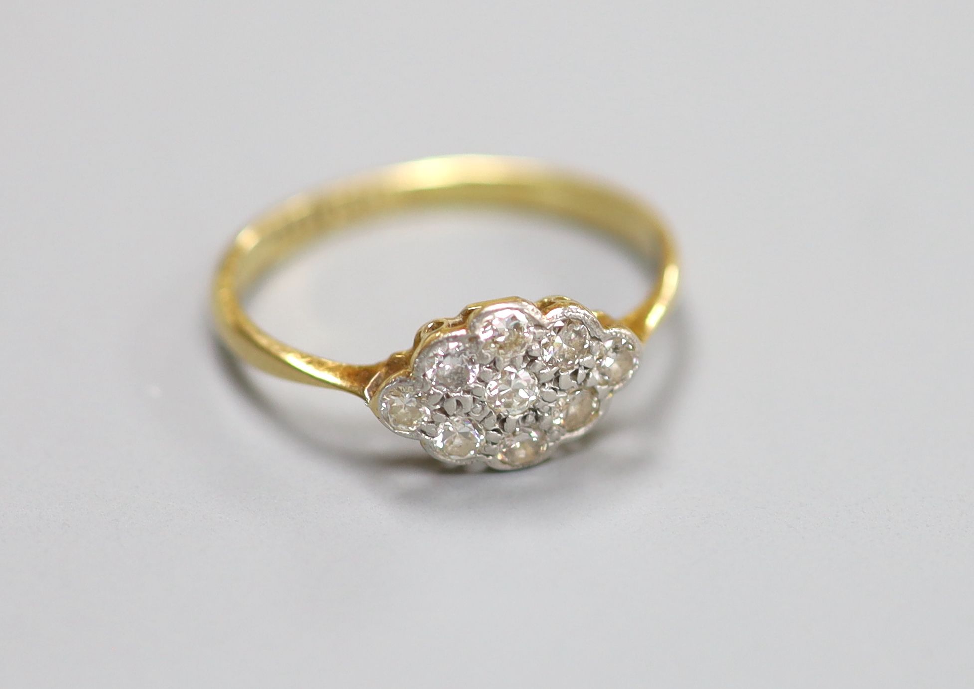 A 1920’s 18ct and plat, nine stone diamond set lozenge shaped cluster ring